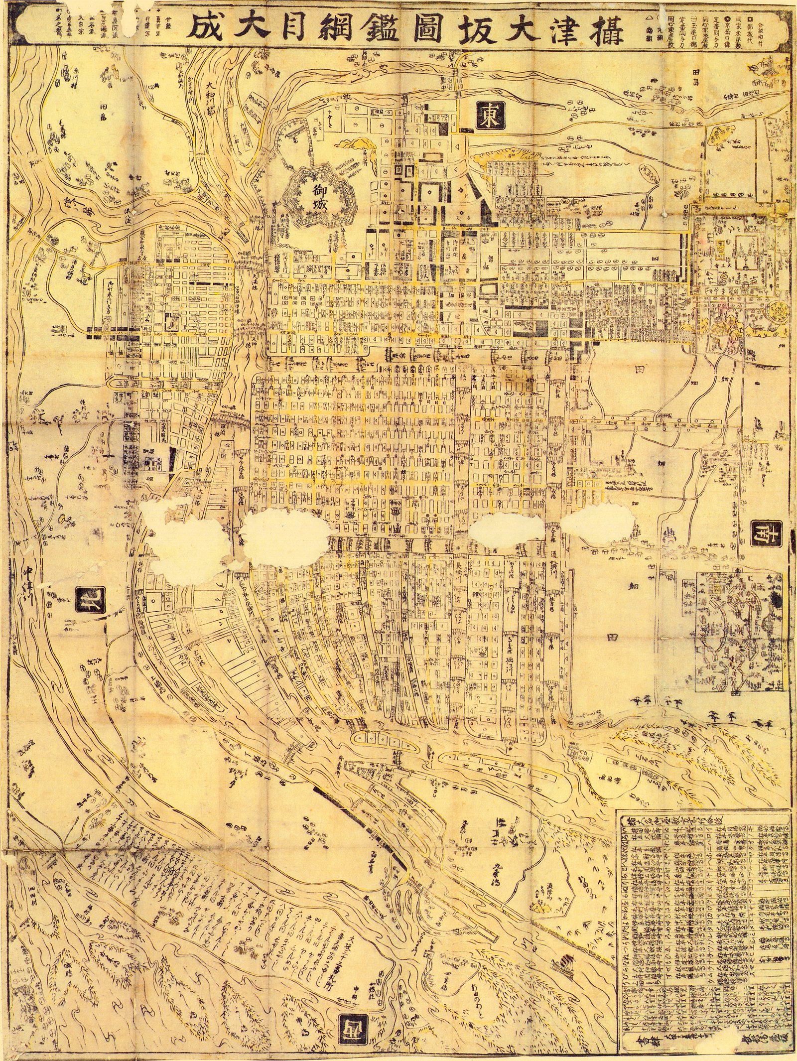 The full title runs in a band across the head of the sheet: 摂津大坂図鑑綱目大成, a complete conspectus of Osaka. East is at the top, the other three directions in black squares down the margins. Only the through-streets take the yellow overprint — the side lanes are bare line — so the routes a stranger would walk stand out of the grid at arm's length.<br><br>御城 is labelled at the upper left, drawn as a plain bastioned outline rather than as a building. Four patches of the sheet are gone: paper loss, reading across the middle of the city as white cloud. It is the only sheet on this page with holes in it.